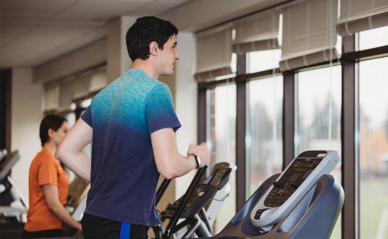 Male student running on treadmill